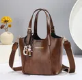 Brown vintage leather bucket bag with top handles, wide strap and doll charm detail - Brown
