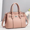 Close-up of pink lychee pattern handbag featuring metal twist lock and stud details - Pink