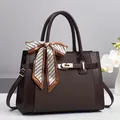 Dettaglio borsa tote marrone con trama a rombi, chiusura dorata e foulard stampato chic - caffè