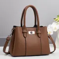 Bolso de piel marrón con textura lichi, cierre giratorio plateado y decoración floral - Marrón