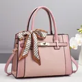 Borsa a mano rosa con texture intrecciata, chiusura dorata e sciarpa decorativa - Rosa