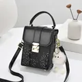Black snake-pattern mini crossbody phone bag with gold clasp and plush monster charm - Black