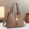 Detailed view of brown woven texture bucket bag with gold buckle and adjustable strap - Brown