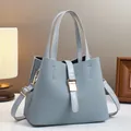 Elegant woven pattern bucket bag in dusty blue with golden hardware and top handles - Blue