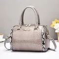 Détail du sac Boston gris à motif crocodile avec bordures serpent et ferrures dorées - Gris