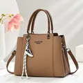 Detail of brown woven texture handbag with Fashion Queen print and mini sneaker charm - Dark Khaki
