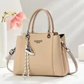Detailansicht der khakifarbenen Lederhandtasche mit Fashion Queen Print und Schuhanhänger - Hellbeige