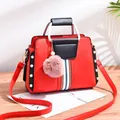 Contrast color red and black PU leather handbag with elegant pearl rivets and fur ball charm - Red