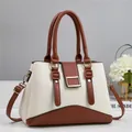 Close-up of cream white and brown crossbody bag with gold buckle and lychee leather texture - Off White