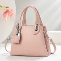 Detail of pink lychee leather bucket bag with silver hardware and heart pendant charm - Pink