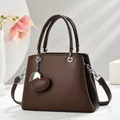 Klassische dunkelbraune Lederhandtasche mit Litschi-Textur und Herzanhänger für Damen - Kaffeebraun