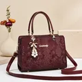 Elegant red snakeskin textured tote bag with pearl bow charm and detachable strap - Burgundy