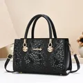 Elegante schwarze Handtasche mit Schlangenmuster, Goldbeschlägen und Griff - Schwarz