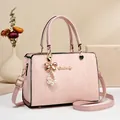 Elegant pink snakeskin pattern tote bag with gold logo and pearl bow charm accessory - Pink