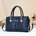 Elegante dunkelblaue Handtasche mit Schlangenmuster, Goldbeschlägen und abnehmbarem Gurt - Blau