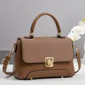 Detail of a brown leather handbag featuring a stylish woven patchwork flap and gold clasp - Apricot
