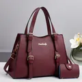 Detail of burgundy lychee grain leather handbag set with tote and small coin purse - Burgundy