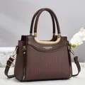 Détail d'un sac à main en cuir marron foncé avec texture rayée et poignée dorée en forme de U - 24cmx12cmx20cm / Café