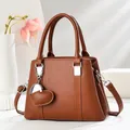 Sac à main élégant en cuir grainé marron avec détails argentés et pendentif coeur - Jaune Terre