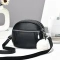 Black textured leather crossbody bag with three zipper compartments and white fur ball charm - 19x15x7 / Black