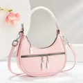 Macro detail van roze halve maan tas met lychee leertextuur en zilveren rits hardware - Roze