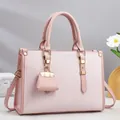 Detail of pink textured leather tote bag featuring elegant gold hardware and small charm - 33x12x23cm / Pink