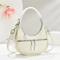Detailweergave van de halvemaanvormige hobo-tas in crème leer met zilveren ritsen - Wit