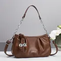 Détail du sac nuage en cuir marron foncé avec chaîne argentée et nœud décoratif - Café