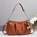 Détail du sac nuage plissé caramel avec poignée en chaîne argentée et breloque boule - Jaune Terre