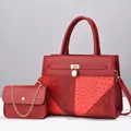 Detail of red embossed ostrich and python texture patchwork on tote with gold lock - Wine Red