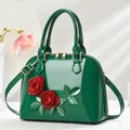 Détail du sac à main vert foncé avec roses 3D rouges et garnitures dorées - Vert