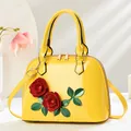 Détail d'un sac à main jaune avec roses 3D et texture en cuir verni brillant - Jaune