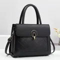 Elegant black quilted leather handbag with gold metal clasp and adjustable shoulder strap - Black
