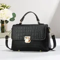 Détail en cuir noir grainé et gaufré croco avec fermoir rotatif et garniture dorée - Noir