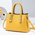 Chic yellow trapezoid handbag with silver chain accents and adjustable shoulder strap - Bright Yellow
