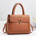 Détail du sac à main en cuir caramel avec fermoir doré et motif matelassé chic - Marron