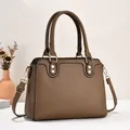 Braune Handtasche aus Leder mit Litschistruktur, Doppelgriffen und Goldnieten - Dunkelbeige