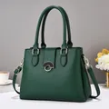 Close-up of green lychee leather handbag with gold buckle and crossbody strap detail - Green