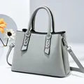 Light gray-blue crossbody handbag with silver chain accents and black edge finishing - Gray