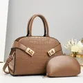 Detail van de bruine tas met reliëf, bijpassende portemonnee en goudkleurige gespen - Handtas en Tasje Set met Krokodillenpatroon (Bruin) / koffiekleur