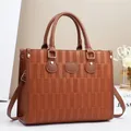 Dettaglio borsa tote caramello in pelle martellata con trama a mattoni e finiture in oro - L32 P12 A25 / Giallo Terra