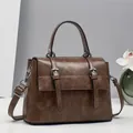 Detail of vintage dark brown tote bag with distressed PU leather texture and buckles - Brown