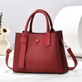 Dettaglio della borsa rossa con trama a onde verticali ed eleganti finiture in metallo oro - Rosso Vino