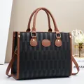 Dettaglio della trama intrecciata nera e finiture in pelle marrone su borsa con fibbie d'oro - L32 P12 A25 / Nero