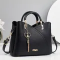 Elegante borsa a mano in pelle nera con finiture dorate e ciondolo a cuore - Lunghezza 23 Altezza 19 Larghezza 11 / Nero