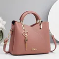Dettaglio borsa in pelle martellata rosa cipria con logo dorato e ciondolo a nappa - Lunghezza 23 Altezza 19 Larghezza 11 / Rosa