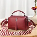 Burgundy faux leather crossbody bag with wide geometric pattern strap on wooden table - 24cmx10cmx14cm / Wine Red