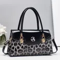 Sac à main chic en cuir verni noir et léopard avec un pendentif coquillage doré - Noir