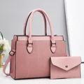 Close-up of pink pleated leather handbag and matching envelope wallet with metallic buckle - Pink