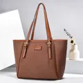 Classic brown tote bag with textured fabric and leather trim displayed on a geometric stand - Earthy Yellow